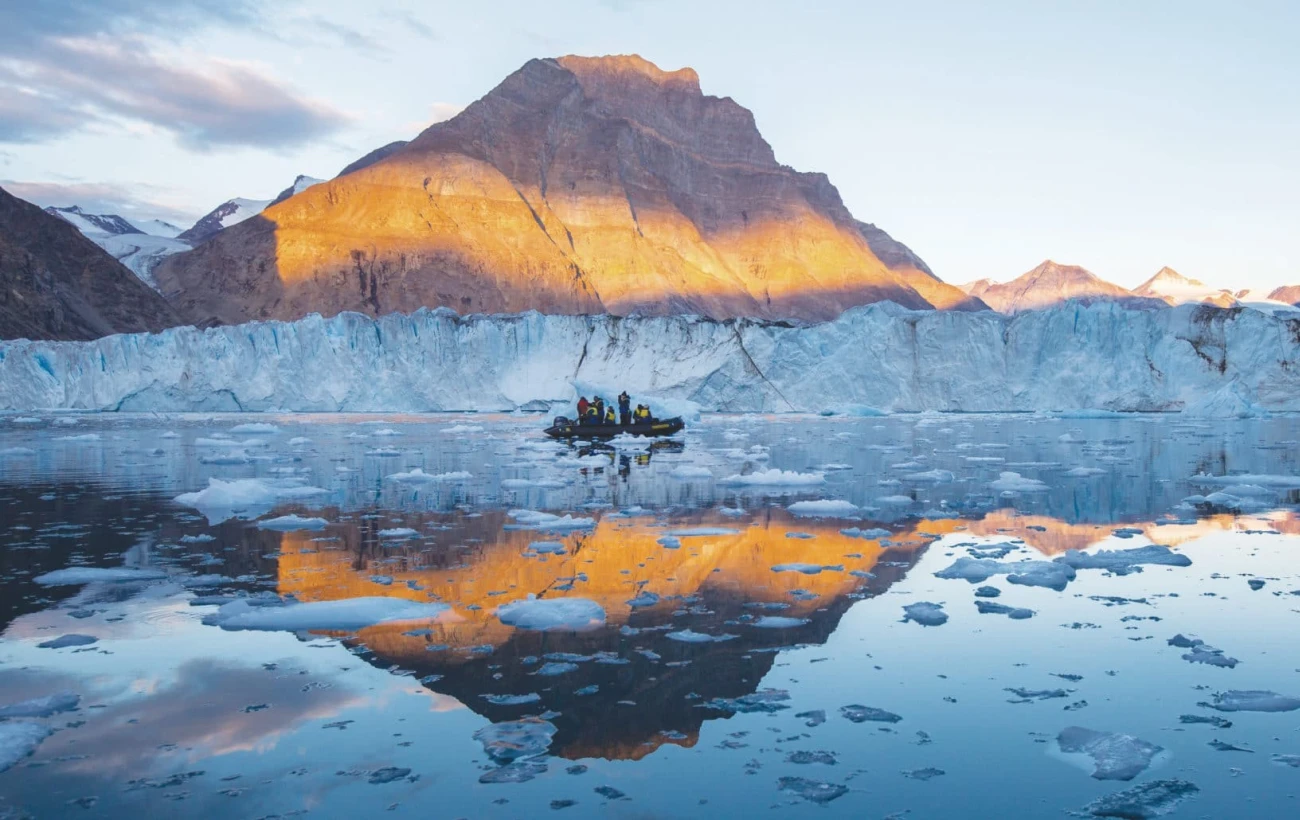 Glacier reflections contrast the red rock landscape
