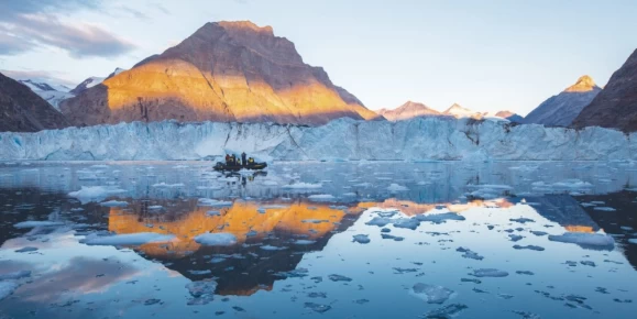 Glacier reflections contrast the red rock landscape