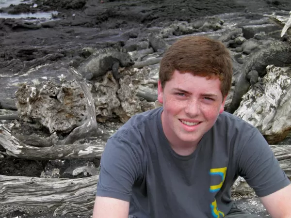 Ben on lava rocks with land iguanas