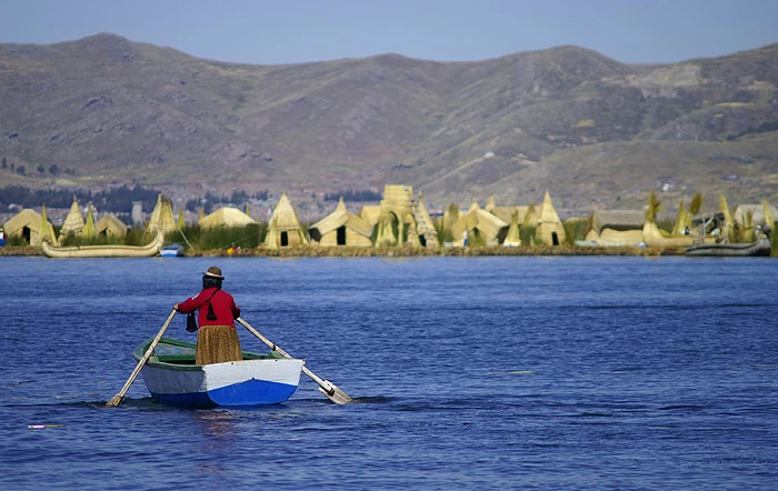 Local Peruvian rows towards shore on Lake Titicaca