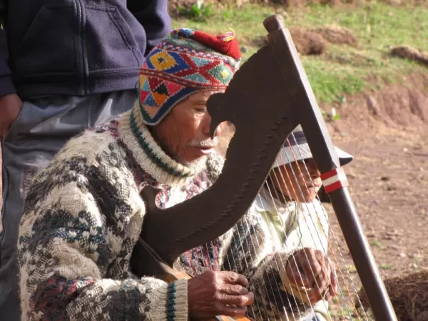 A man plays his harp as we hike the Cachiccata Trek
