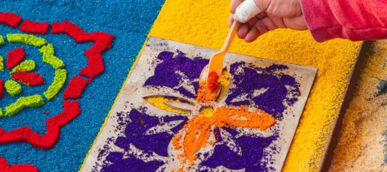 Creating alfombra decorations from brightly colored sawdust for Semana Santa Holy Week Easter celebrations