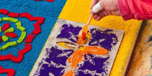 Creating alfombra decorations from brightly colored sawdust for Semana Santa Holy Week Easter celebrations