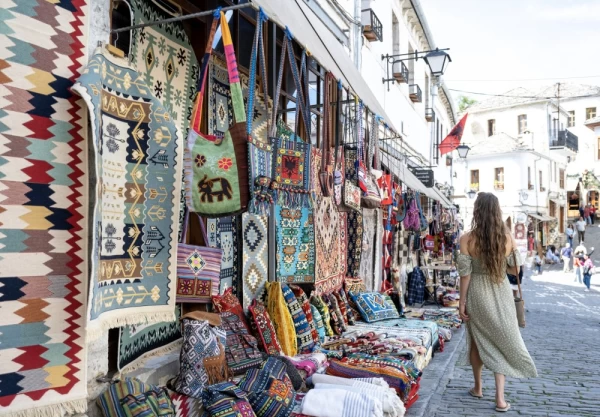 Woman explores outdoor market on old village streets