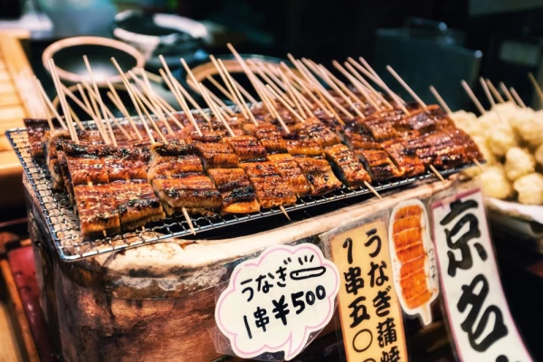 Grilled unagi or fresh water eel on sticks as street food at Nishiki market in Kyoto