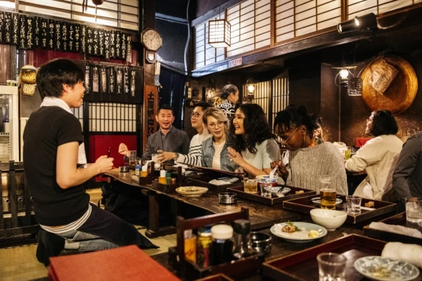 Group of friends ordering food in Japanese Izakaya