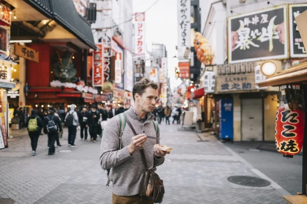 Tourist eating takoyaki - octopus balls