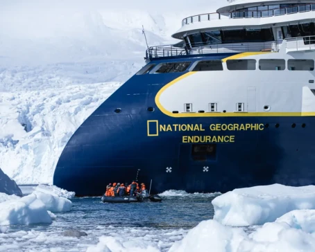 The National Geographic Endurance with a backdrop of rugged mountains.