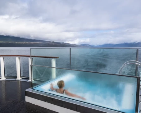 A guest relaxing in the Infinity Edge Pool while soaking in the breathtaking views of the wild Patagonia