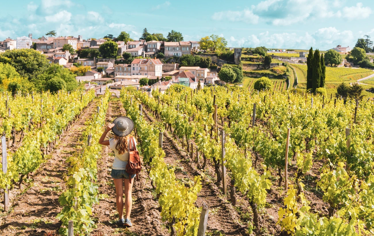 Woman enjoying Saint Emilion village in green vineyard, Bordeaux in France
