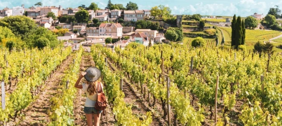 Woman enjoying Saint Emilion village in green vineyard, Bordeaux in France