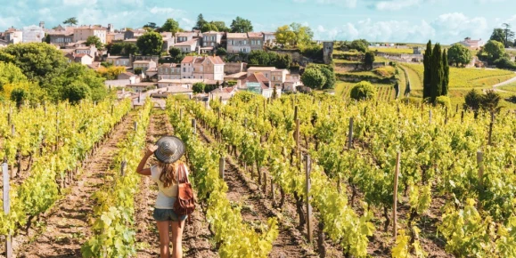 Woman enjoying Saint Emilion village in green vineyard, Bordeaux in France