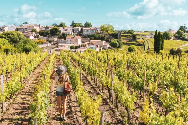 Woman enjoying Saint Emilion village in green vineyard, Bordeaux in France