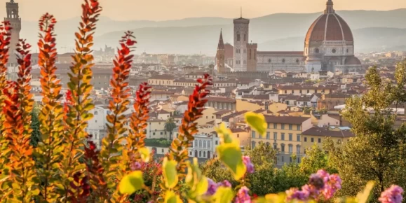Iconic Duomo view framed by vibrant foliage in warm Tuscan light in Florence