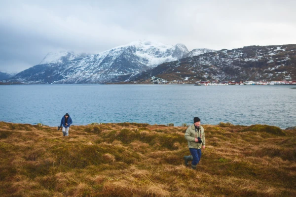 Two photographers are walking on the hill of Lofoten islands, winter time