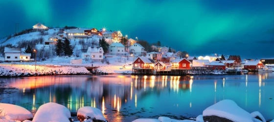 Dramatic evening cityscape of Reine town with Northern Lights