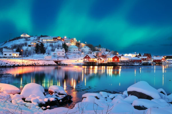 Dramatic evening cityscape of Reine town with Northern Lights