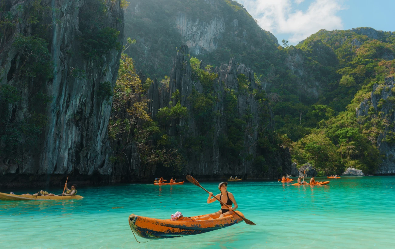 Carefree woman kayaking on El Nido, Philippines