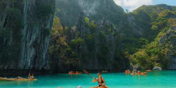 Carefree woman kayaking on El Nido, Philippines