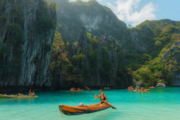 Carefree woman kayaking on El Nido, Philippines