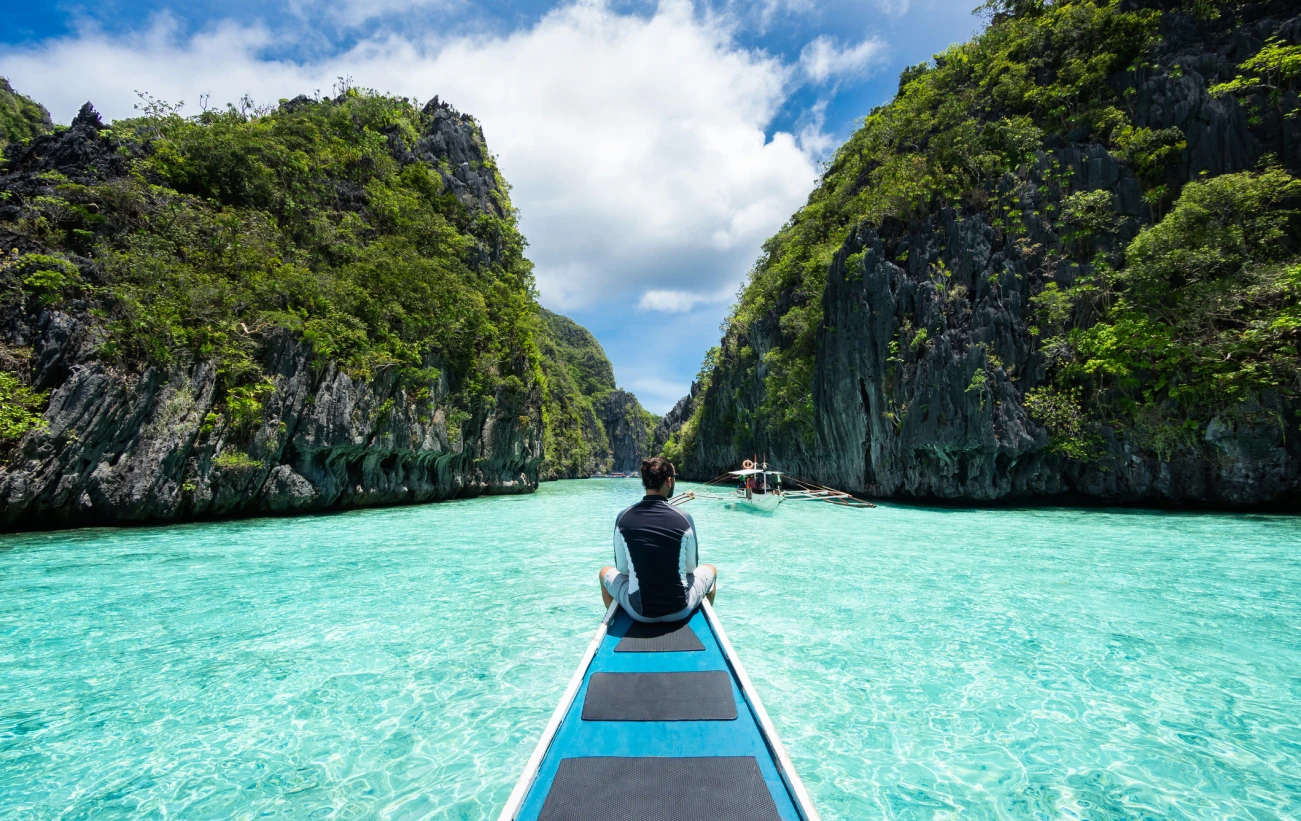 traveler sitting on boat exploring the natural sights around El Nido