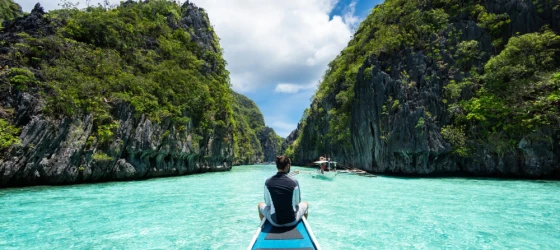 traveler sitting on boat exploring the natural sights around El Nido