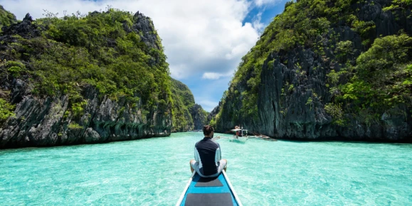 traveler sitting on boat exploring the natural sights around El Nido