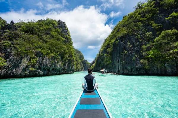 traveler sitting on boat exploring the natural sights around El Nido