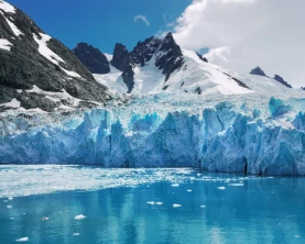 Blue and turquoise color ice of glacier face and reflections in calm water of Drygalski Fjord, South Georgia Island.