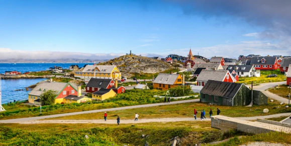Tourists and visitors roam the streets and pathways around the colorful homes and buildings of Nuuk, Greenland