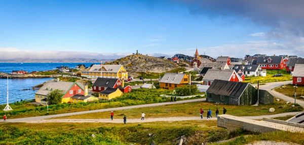 Tourists and visitors roam the streets and pathways around the colorful homes and buildings of Nuuk, Greenland