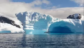 Beautiful blue icebergs emerge from the ocean.