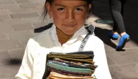 Adorable Peruvian girl selling scarves