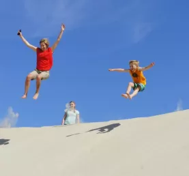 Jumping down a sand dune in Mexico