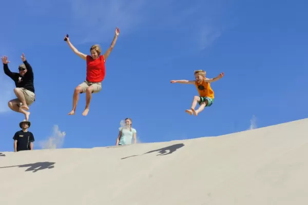Jumping down a sand dune in Mexico