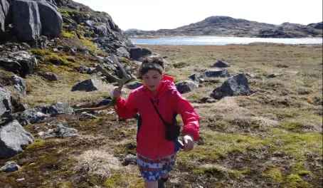 My daughter finds a caribou antler as we hike the terrain 