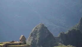 Reconstructed Inca hut and Wayna Picchu at Machu Picchu, Peru