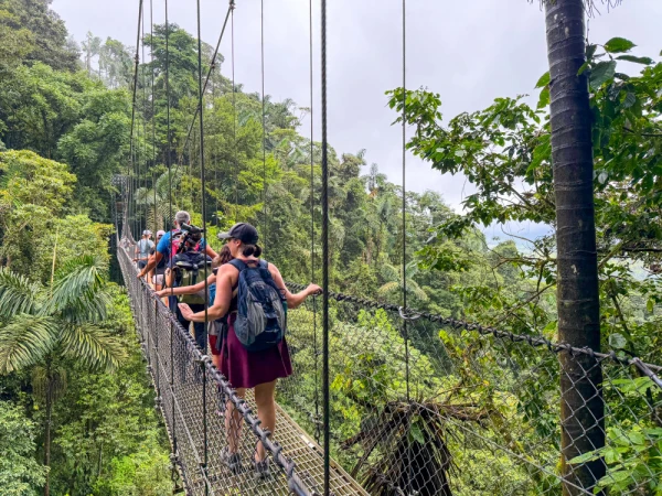 Erin and her family exploring Mistico Arenal Hanging Bridges Park in Costa Rica, walking across suspension bridges and forest trails surrounded by lush tropical vegetation near Arenal Volcano.