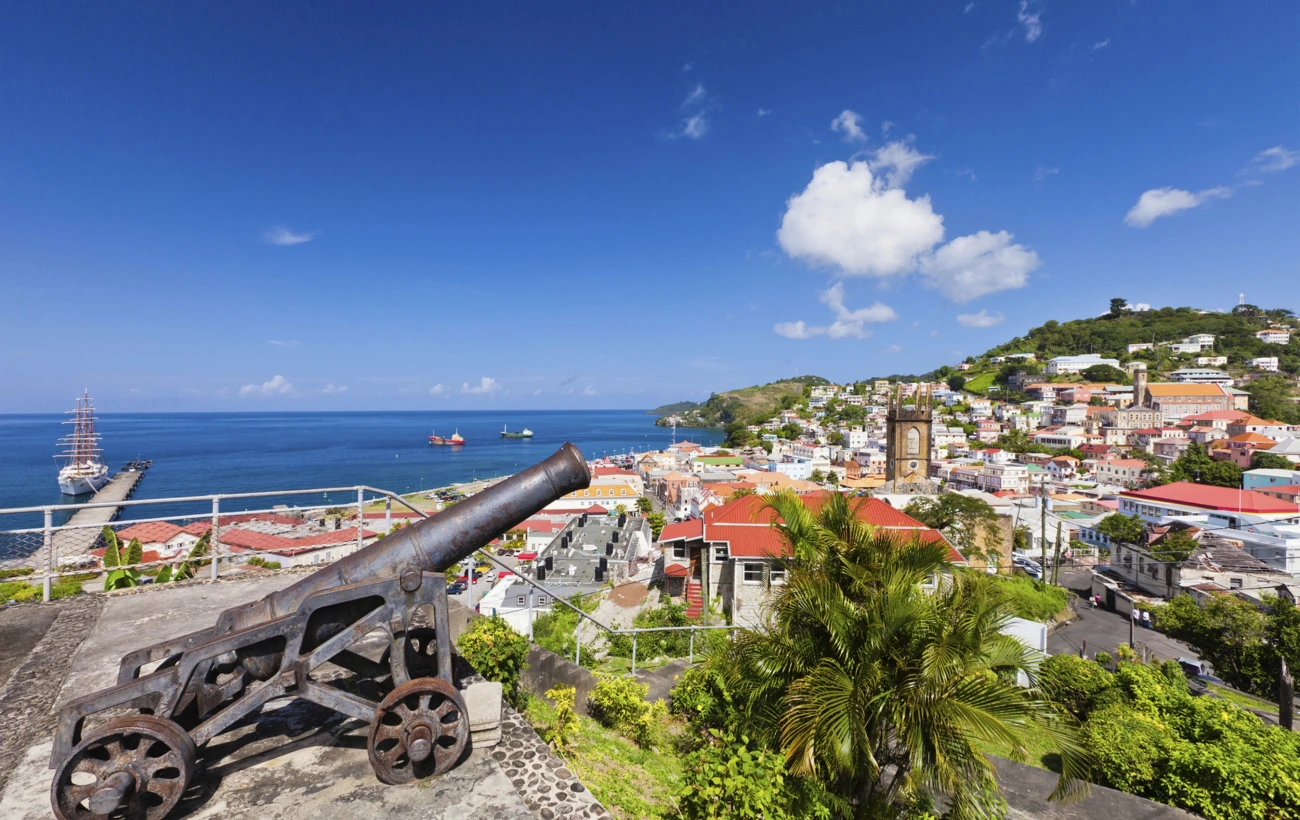St. George's harbor in Grenada, where historic cannons overlook scenic ocean views and colorful hillside estates