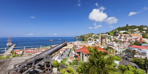St. George's harbor in Grenada, where historic cannons overlook scenic ocean views and colorful hillside estates