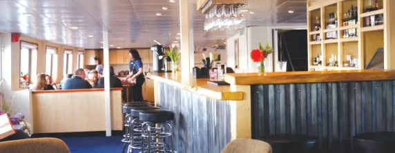 Enjoy a drink at the bar aboard the Wilderness Discoverer.
