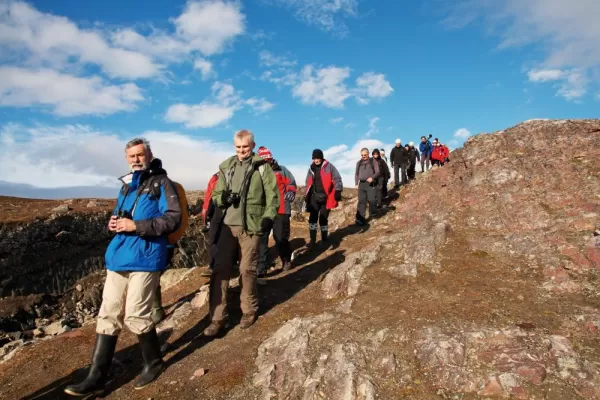 Travelers hiking through the Norwegian arctic.