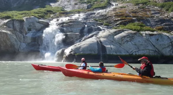 Kayaking past a waterfall.