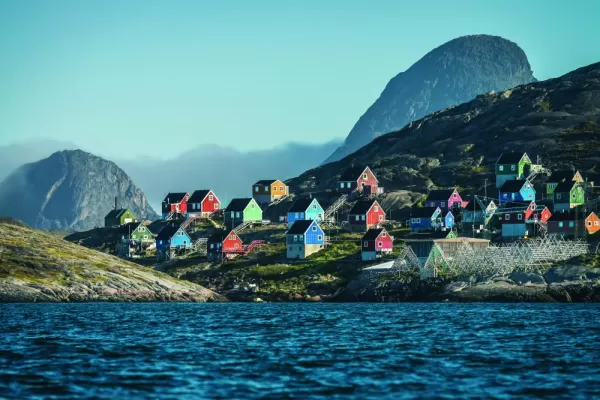 An arctic village full of colorful houses sits on the arctic coast.