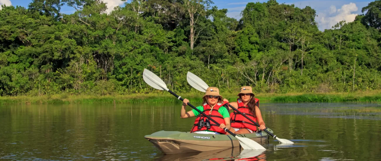 Two kayakers making their way down the Amazon River.
