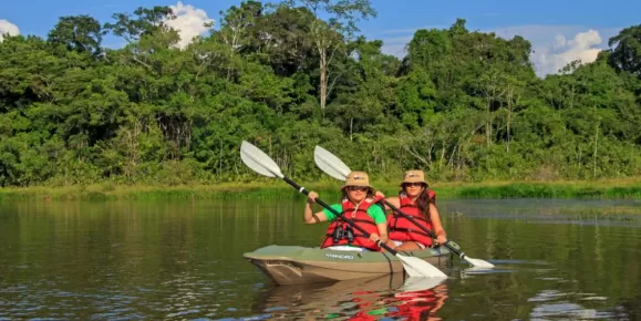 Two kayakers making their way down the Amazon River.