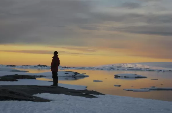 A traveler stares into the arctic sunset.