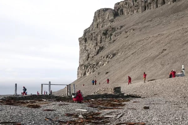 Travelers walking around the arctic landscape.