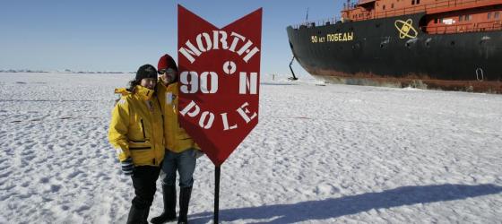 Travelers standing next to the North Pole.