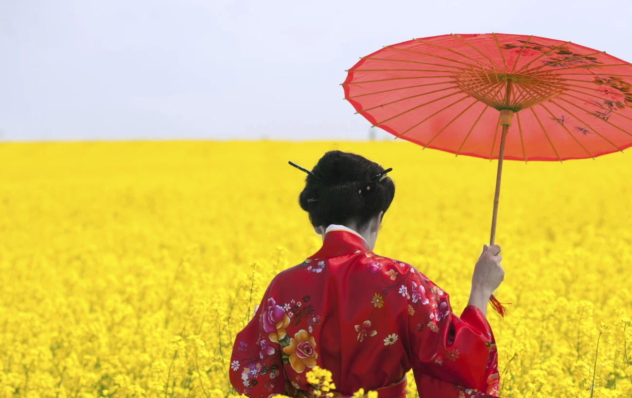 A young woman walks through a field of flowers